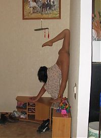 Sport and Fitness: young brunette girl doing flexible gymnastics at home